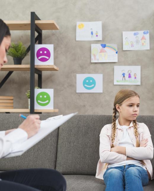 depressed-girl-sitting-sofa-with-female-psychologist-writing-note-clipboard